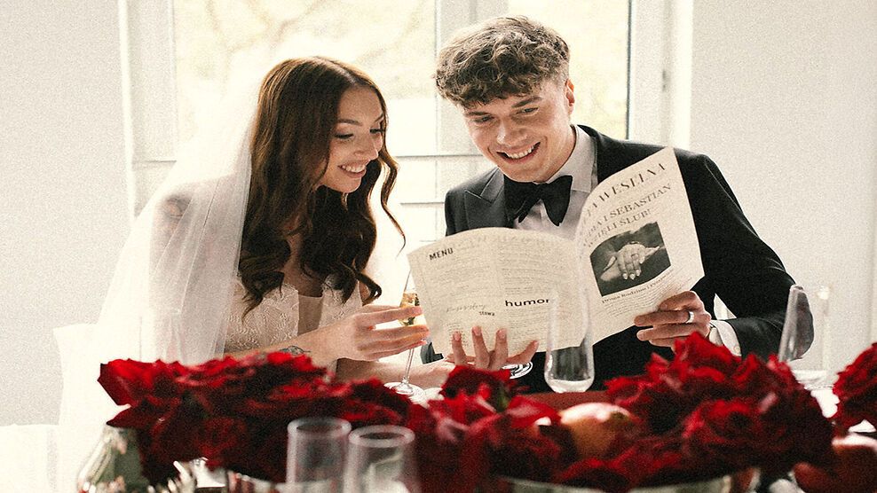 Para czytająca menu przy stole z czerwonymi różami
